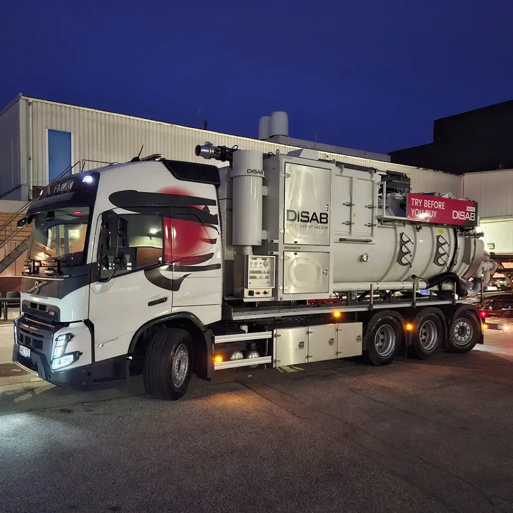 Disab Centurion P20 -suurtehoimuri valkoisella kolmiakselisella alustalla, kuvattuna teollisuusalueella iltavalaistuksessa. Ajoneuvon kyljessä näkyvissä alipaineyksikkö ja säiliörakenne DISAB-logomerkinnällä.
