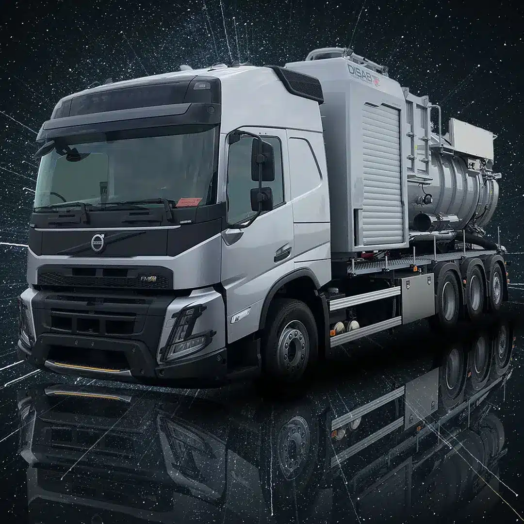 Disab Futurion Q10 suurtehoimuri asennettuna Volvo-kuorma-auton alustalle. Kuvassa näkyy harmaa, moniakselinen imuriauto, jossa on suuri teollinen imuyksikkö ja suljettu säiliö. Taustalla tumma, futuristinen grafiikka.