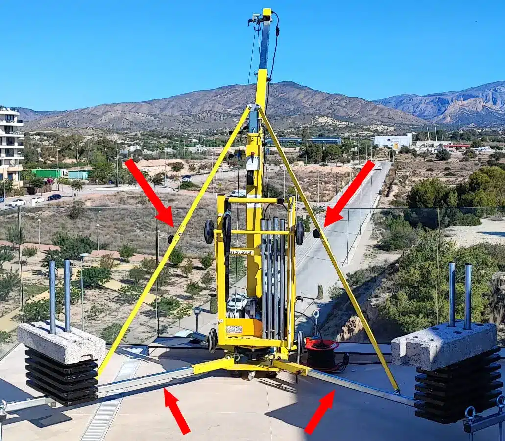 Elevall 400 -kerrosnosturin vastapainovarustus asennettuna; punaiset nuolet osoittavat tukijalkojen ja vinotukien kiinnityskohdat nosturin rakenteessa.